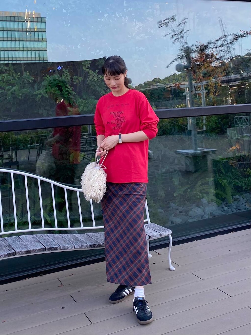 ブラック系のスニーカー、ホワイト系のハンドバッグ、その他のTシャツ/カットソーを着用したレディースの秋コーディネートの1枚目の写真