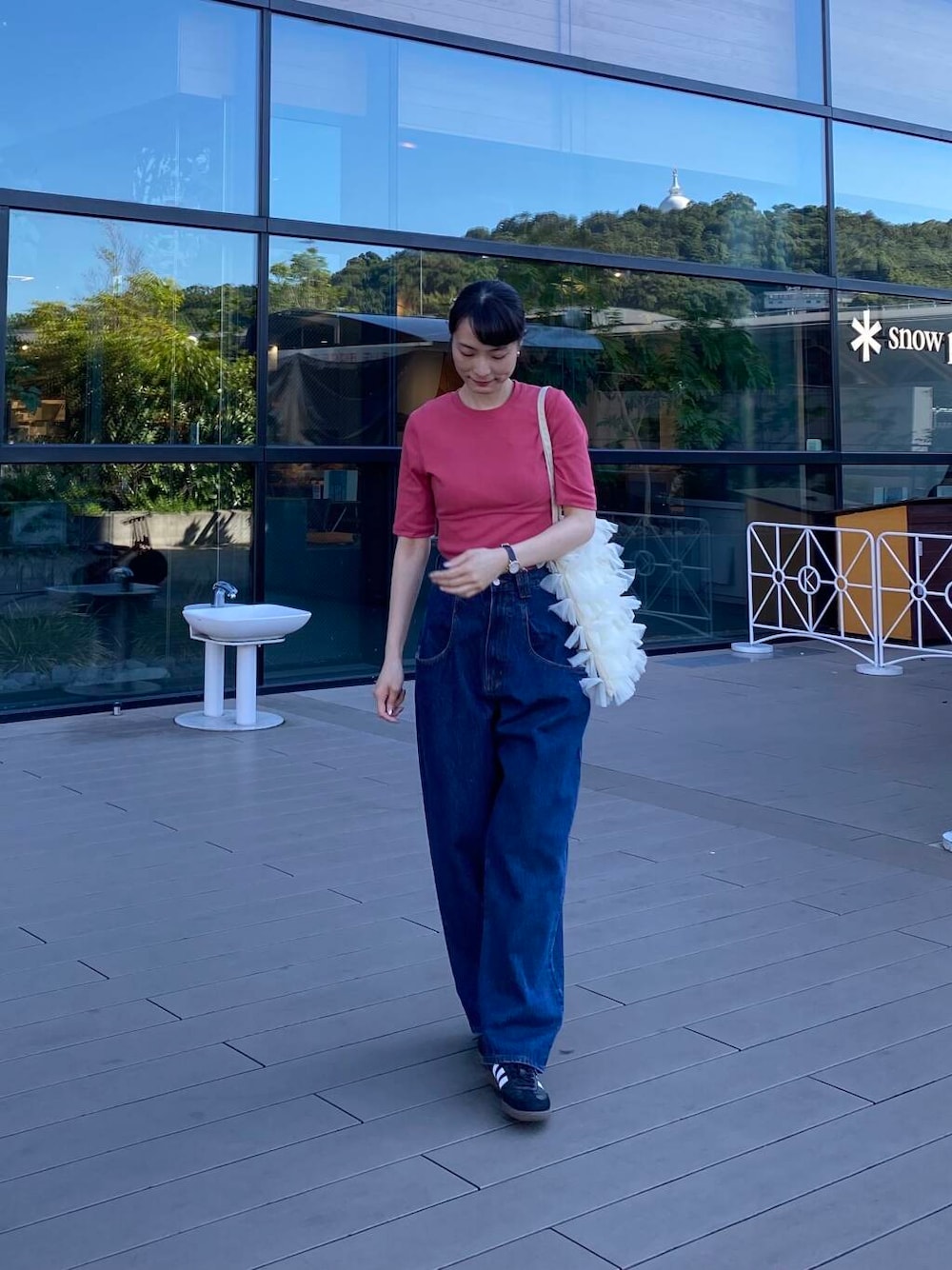 ブルー系のデニムパンツ、ホワイト系のトートバッグ、ブラック系のスニーカーを着用したレディースの夏コーディネートの1枚目の写真