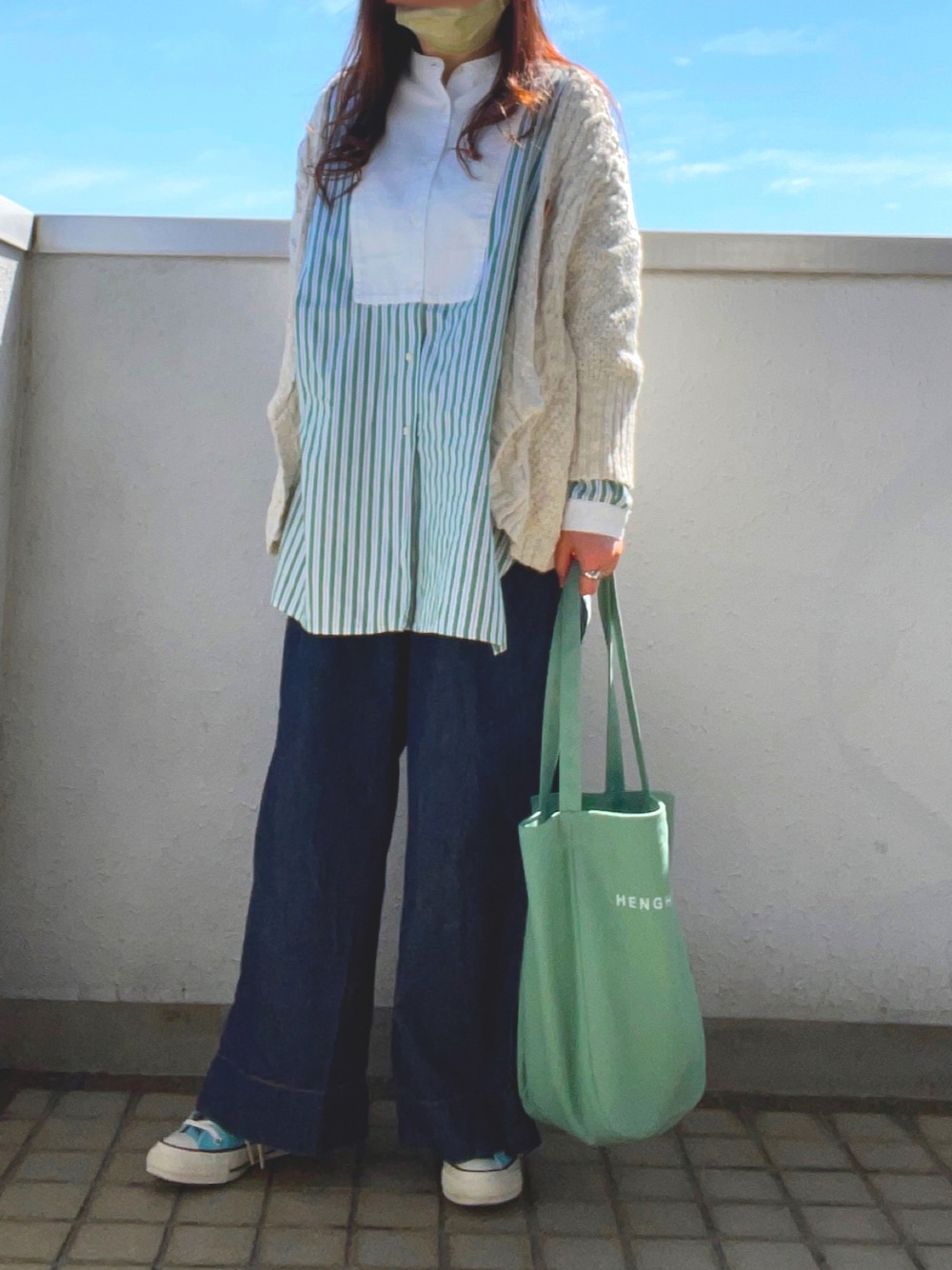 グリーン系のシャツ/ブラウス、グリーン系のトートバッグ、ブルー系のスニーカーを着用したレディースの春コーディネートの1枚目の写真