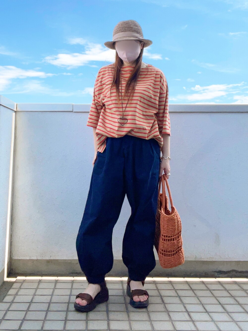 イエロー系のTシャツ/カットソー、ブルー系のデニムパンツ、ブラウン系のトートバッグを着用したレディースの夏コーディネートの1枚目の写真