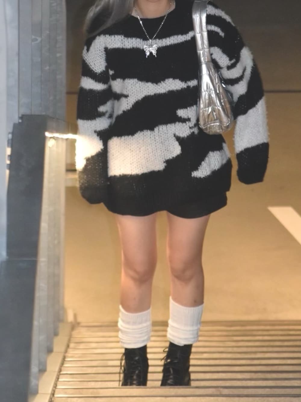 ブラック系のニット/セーター、ブラック系のその他パンツ、ブラック系のブーツを着用したレディースの冬コーディネートの1枚目の写真