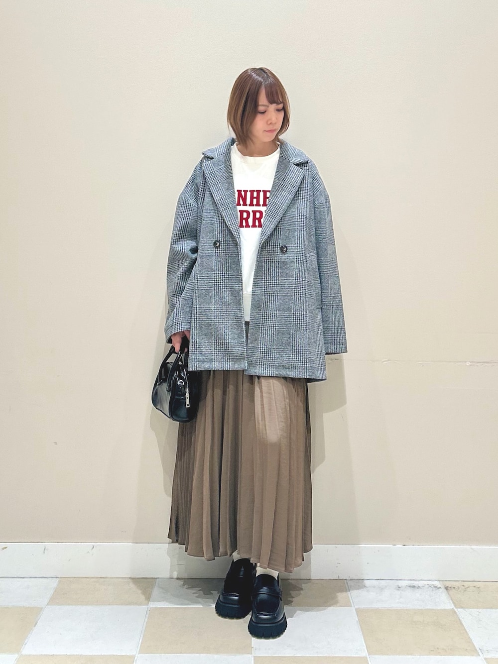 ホワイト系のスウェット、グリーン系のノーカラーコート、ブラウン系のスカートを着用したレディースの秋コーディネートの1枚目の写真