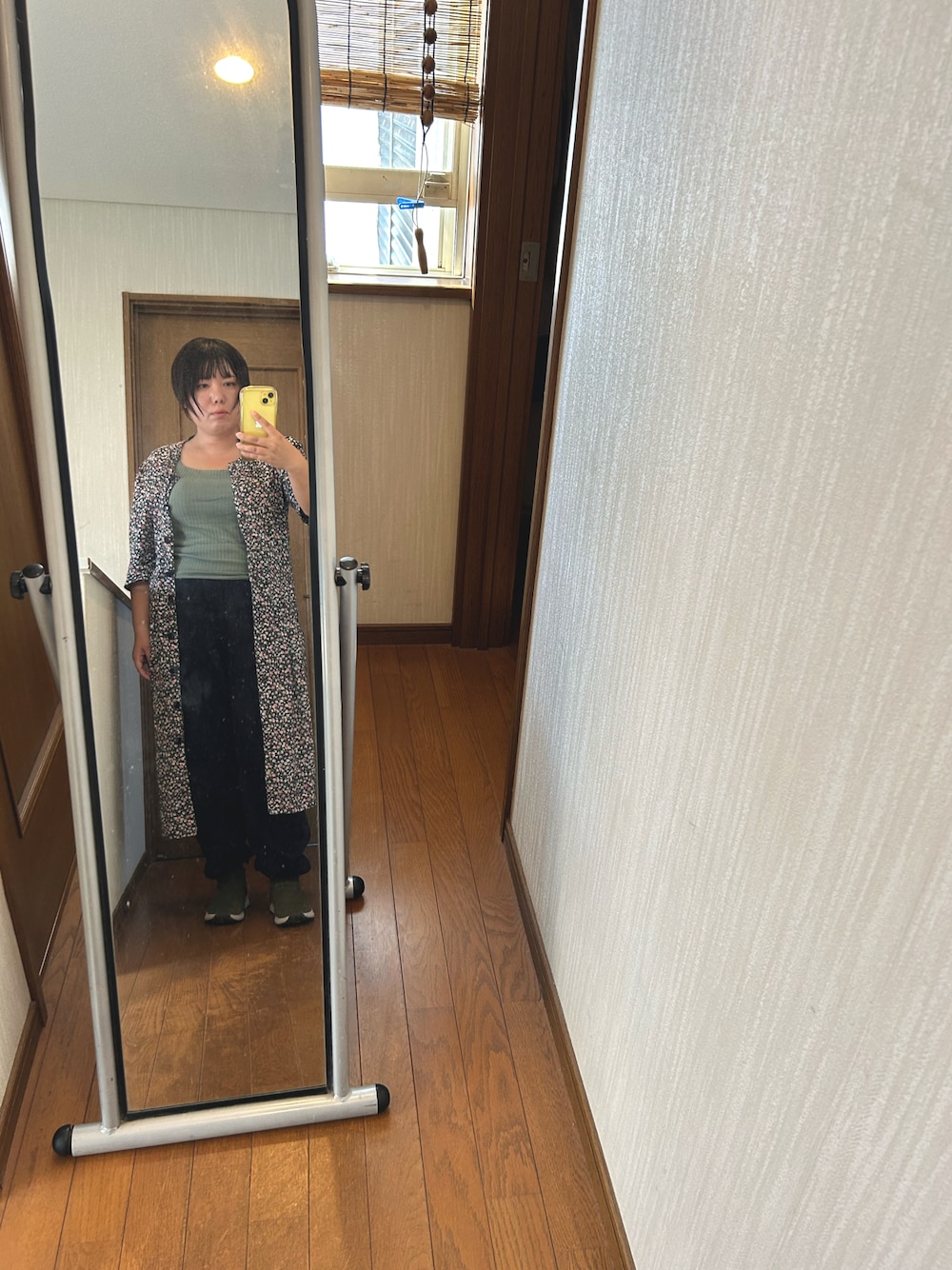 グリーン系のキャミソール、ブルー系のスウェットパンツ、グリーン系のシューズを着用したレディースの秋コーディネートの1枚目の写真