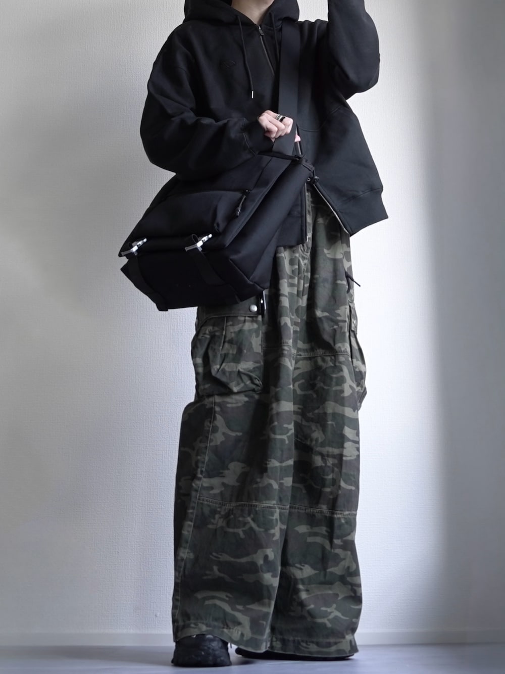 「パーカー、ジップパーカ、カーゴパンツ、カモフラパンツ、ストリート、デカバッグ、春コーデ」｜「CLELの【CLEL】Heavy Weight Logo Embroidered Full-Zip Hoodie/ヘビーウェイト ロゴ刺繍フルジップパーカー（パーカー、ブラック系）」を使った、つぐ吉さん（メンズ・173cm）の冬コーディネートの1枚目の写真