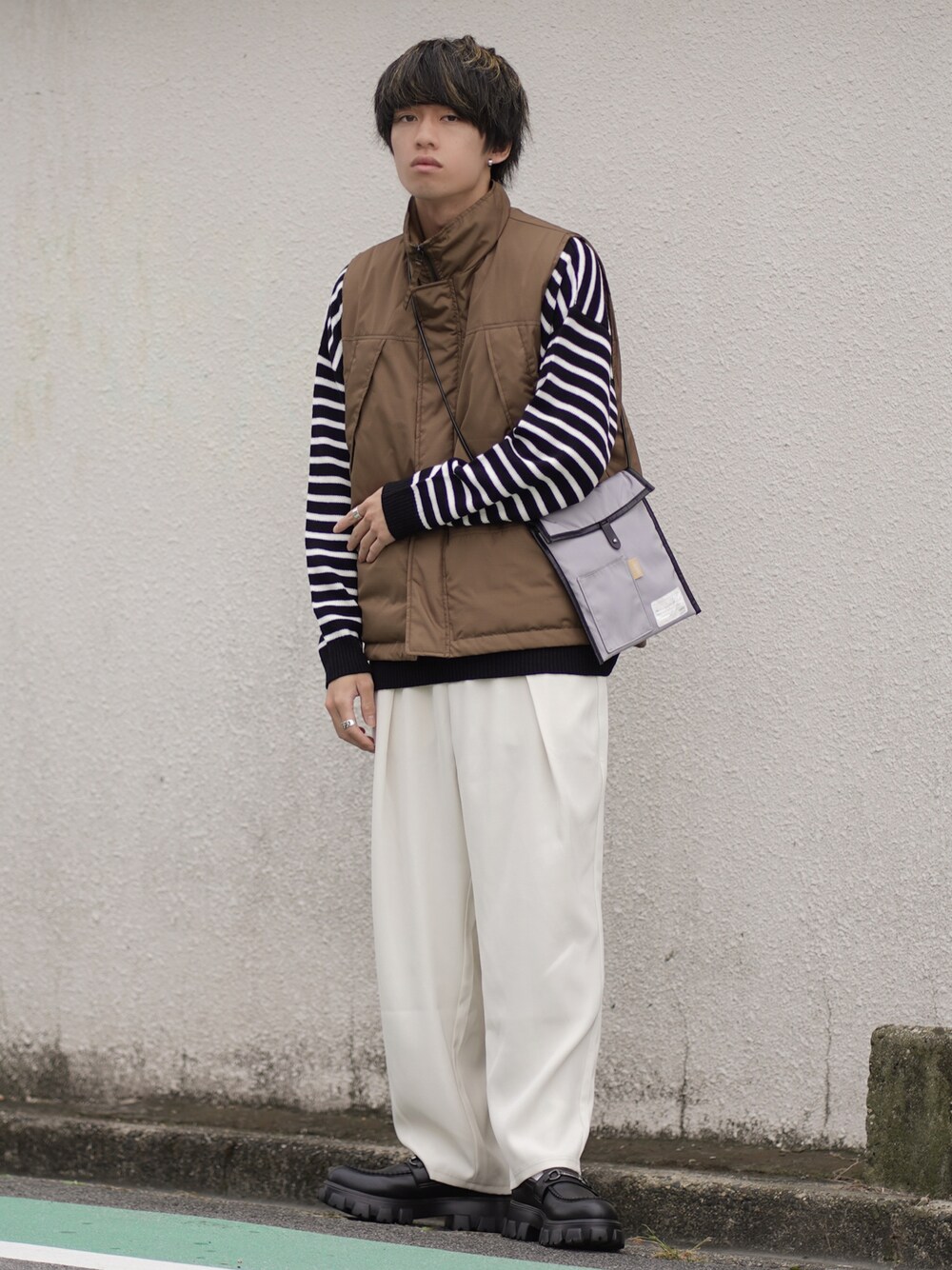 ブラウン系のダウンベスト、ホワイト系のその他パンツ、ブラック系のローファーを着用したメンズの秋コーディネートの1枚目の写真