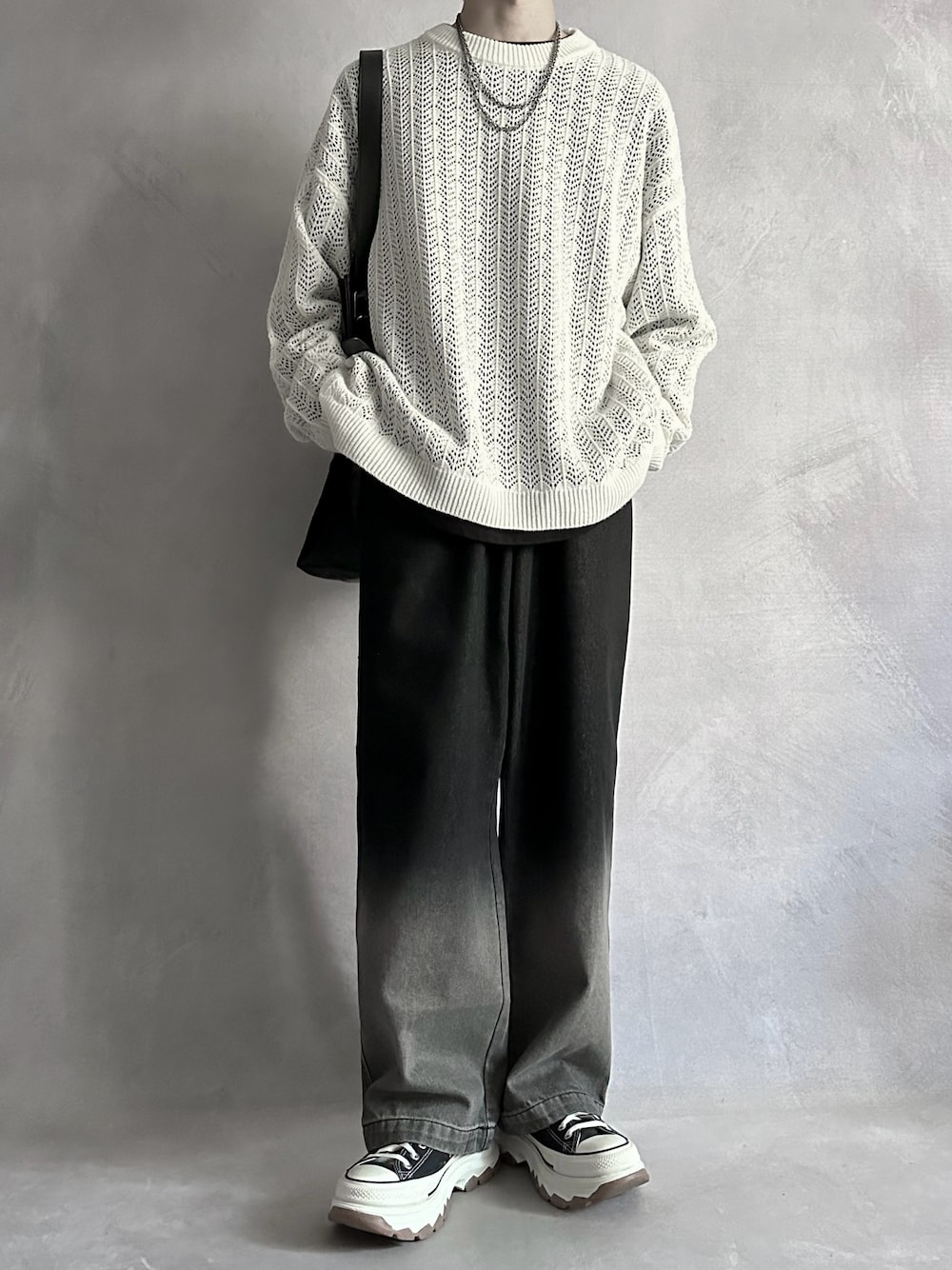 ホワイト系のニット/セーター、ブラック系のTシャツ/カットソー、ブラック系のデニムパンツを着用したメンズの夏コーディネートの1枚目の写真