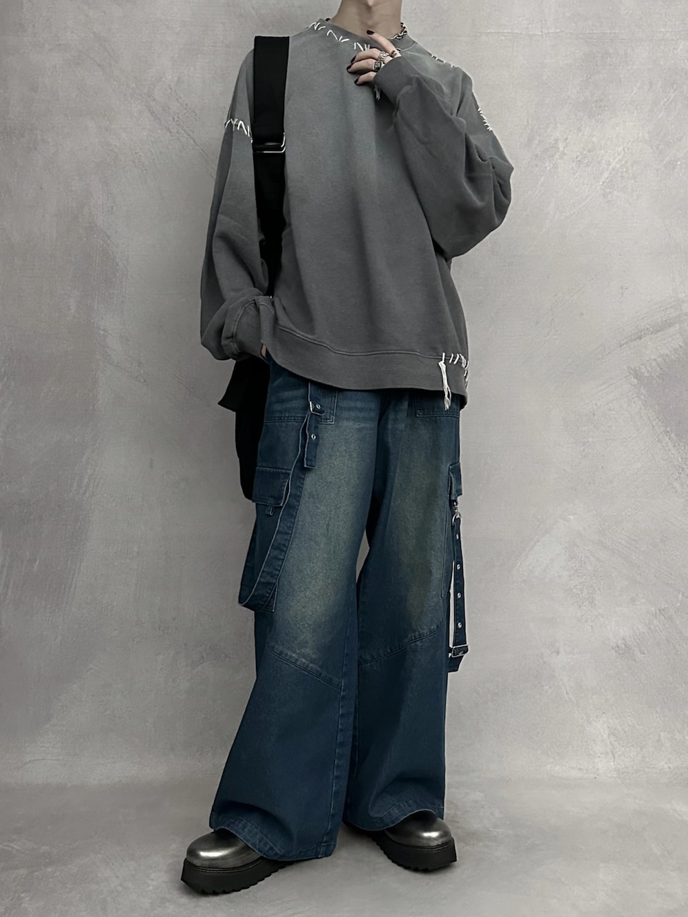 グレー系のスウェット、ブルー系のカーゴパンツ、ブラック系のショルダーバッグを着用したメンズの秋コーディネートの1枚目の写真