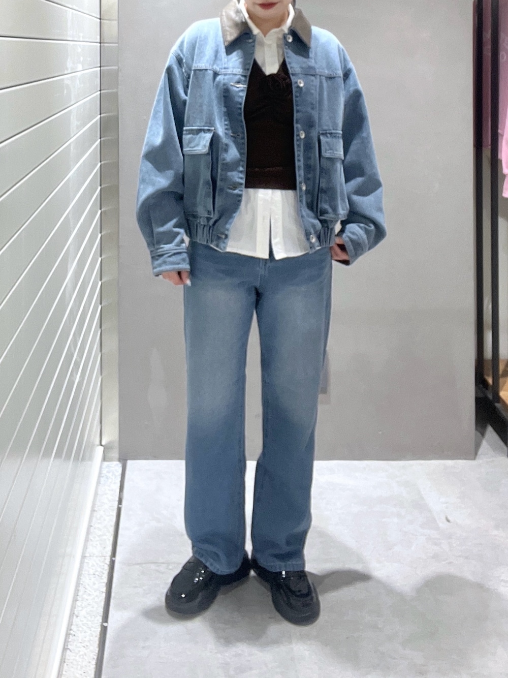 ブルー系のデニムジャケット、ホワイト系のシャツ/ブラウス、ブラウン系のニット/セーターを着用したレディースの冬コーディネートの1枚目の写真