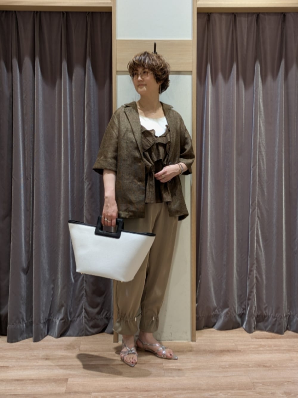 シルバー系のサンダル、ブラウン系のその他パンツ、ホワイト系のハンドバッグを着用したレディースの春コーディネートの1枚目の写真