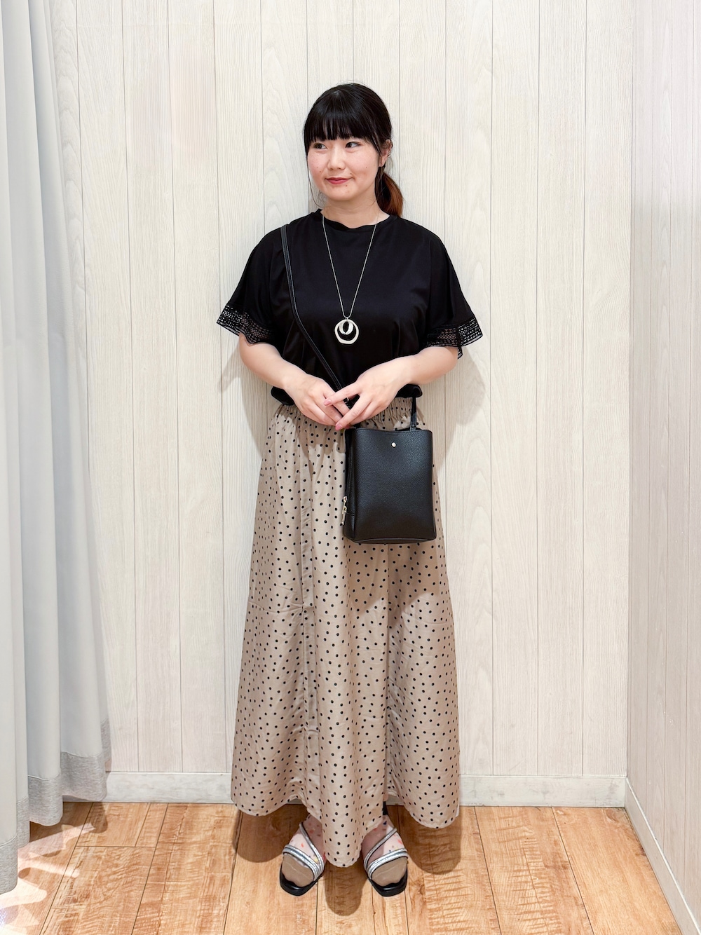 ブラック系のTシャツ/カットソー、ブラウン系のスカート、ブラック系のサンダルを着用したレディースの夏コーディネートの1枚目の写真