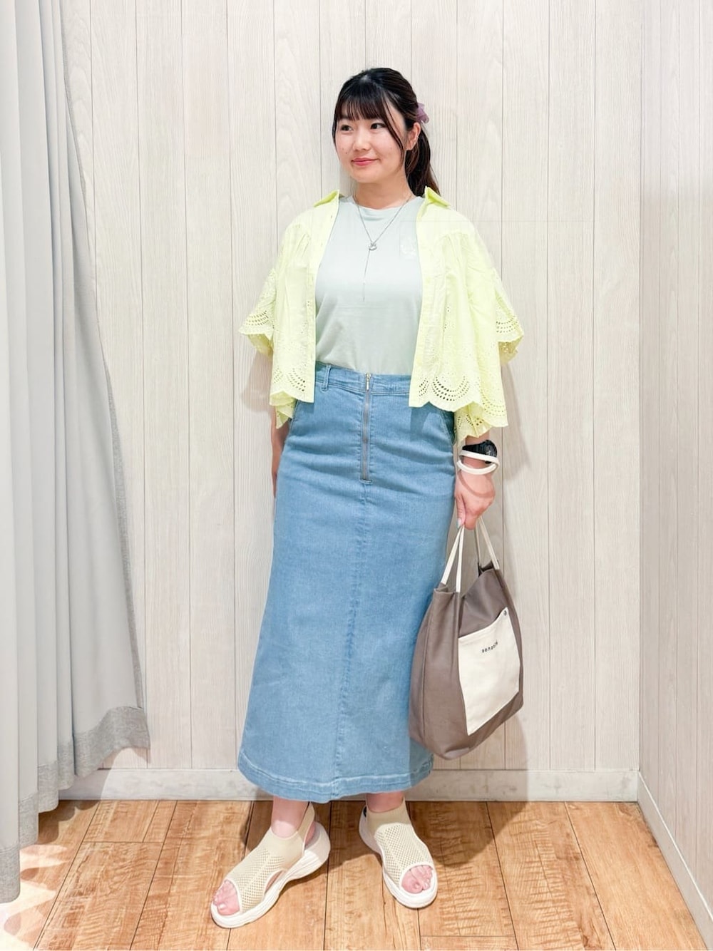 イエロー系のシャツ/ブラウス、グリーン系のTシャツ/カットソー、ブルー系のデニムスカートを着用したレディースの夏コーディネートの1枚目の写真