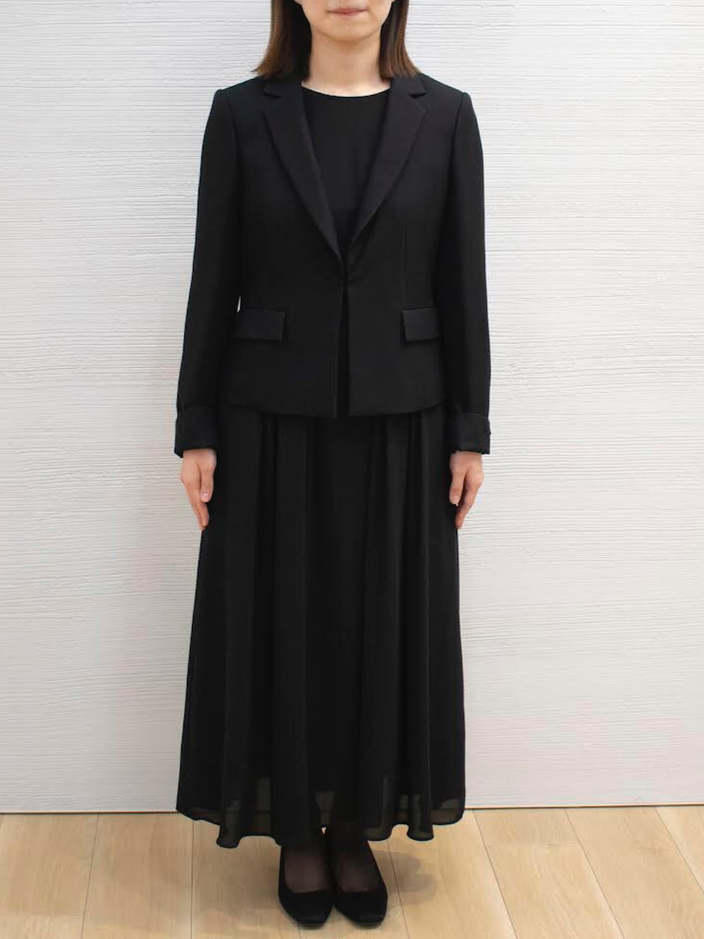 ブラック系のスーツセットを着用したレディースの春コーディネートの1枚目の写真