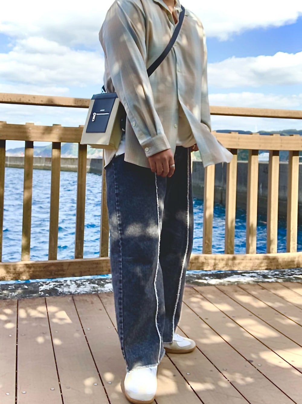 ベージュ系のシャツ/ブラウス、ブラック系のデニムパンツ、ベージュ系のショルダーバッグを着用したメンズの秋コーディネートの1枚目の写真