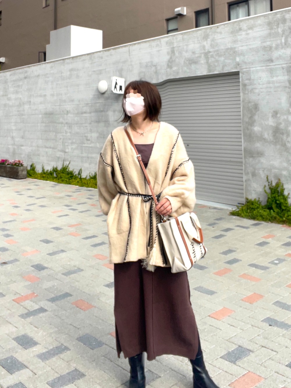 ホワイト系のカーディガン/ボレロ、ブラウン系のワンピース、ブラック系のブーツを着用したレディースの秋コーディネートの1枚目の写真