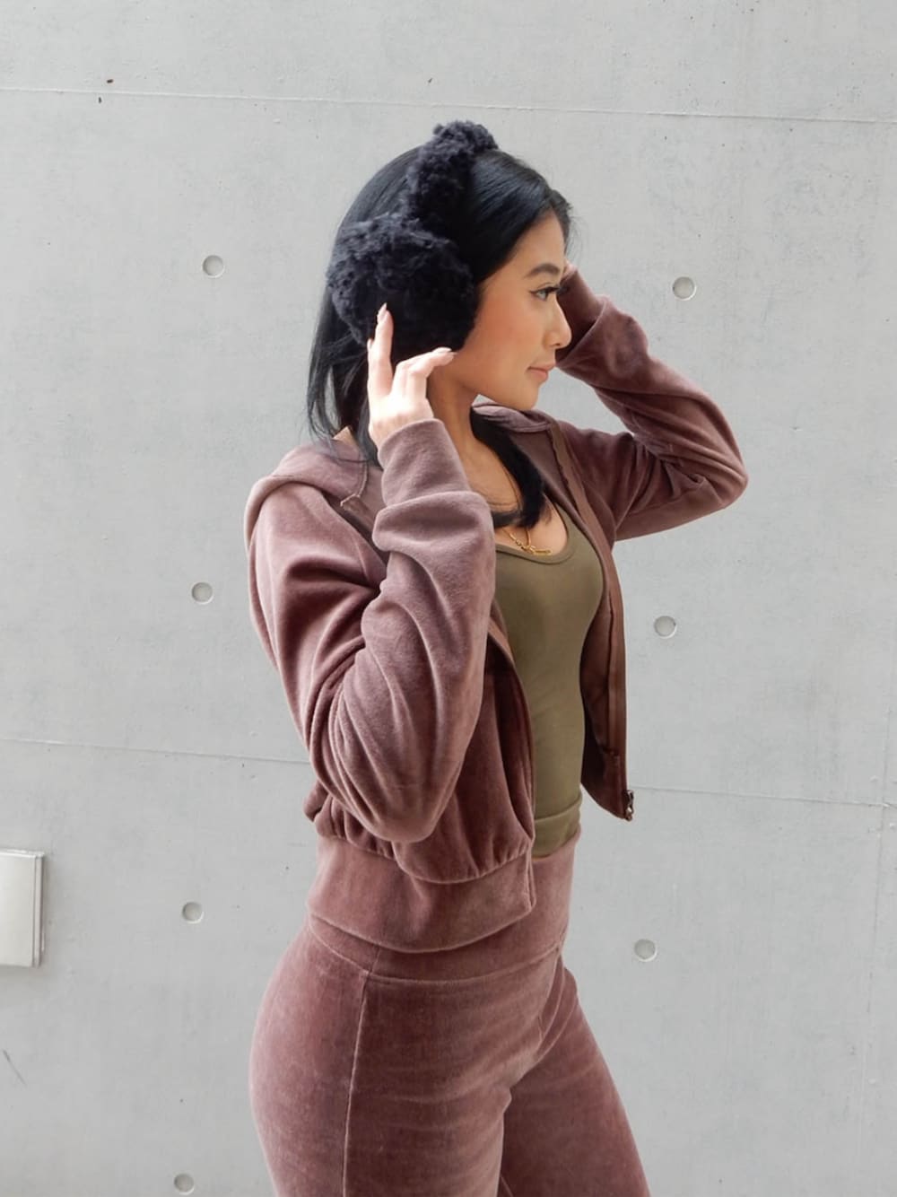 ブラウン系のその他パンツ、ブラウン系のパーカー、ブラック系のイヤーマフを着用したレディースの秋コーディネートの1枚目の写真