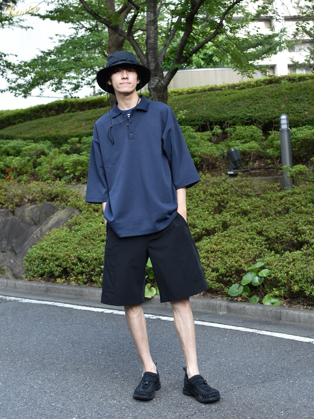 ブルー系のポロシャツ、ブルー系のTシャツ/カットソー、ブラック系のカーゴパンツを着用したメンズの夏コーディネートの1枚目の写真