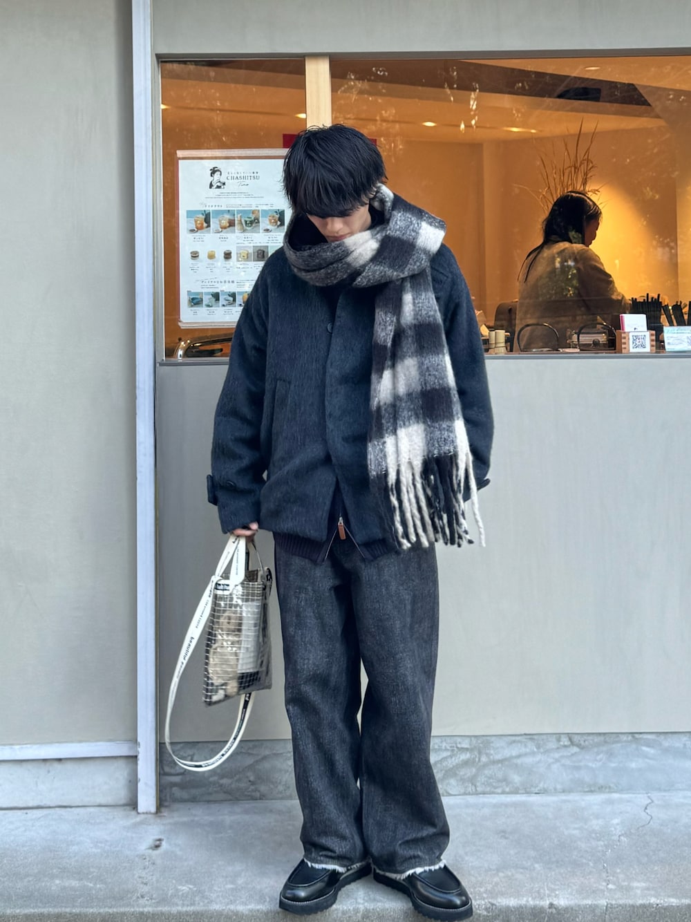ブラック系のデニムパンツ、ブラック系のモカシン/デッキシューズ、ブラック系のブルゾンを着用したメンズの冬コーディネートの1枚目の写真