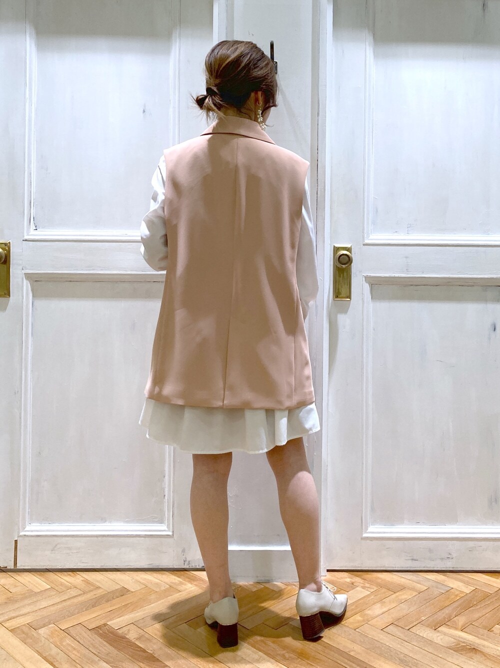 ピンク系のテーラードジャケット、ホワイト系のトップス、ブラウン系のショルダーバッグを着用したレディースの春コーディネートの5枚目の写真