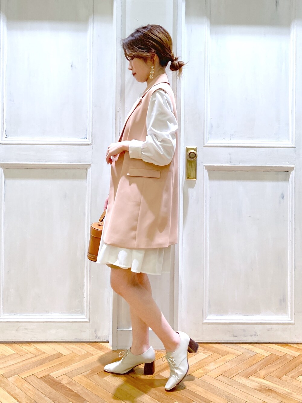 ピンク系のテーラードジャケット、ホワイト系のトップス、ブラウン系のショルダーバッグを着用したレディースの春コーディネートの4枚目の写真
