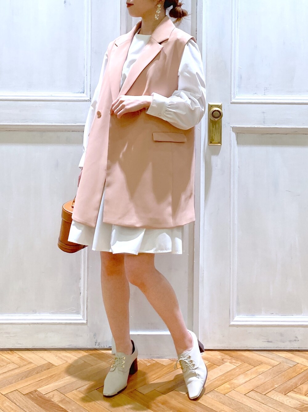 ピンク系のテーラードジャケット、ホワイト系のトップス、ブラウン系のショルダーバッグを着用したレディースの春コーディネートの3枚目の写真