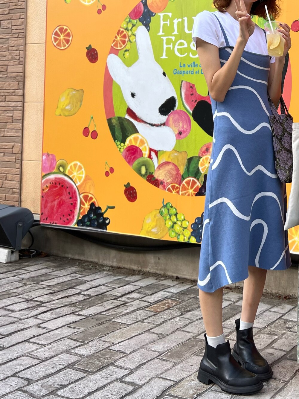 ブルー系のワンピース、ブラック系のブーツ、パープル系のハンドバッグを着用したレディースの冬コーディネートの1枚目の写真