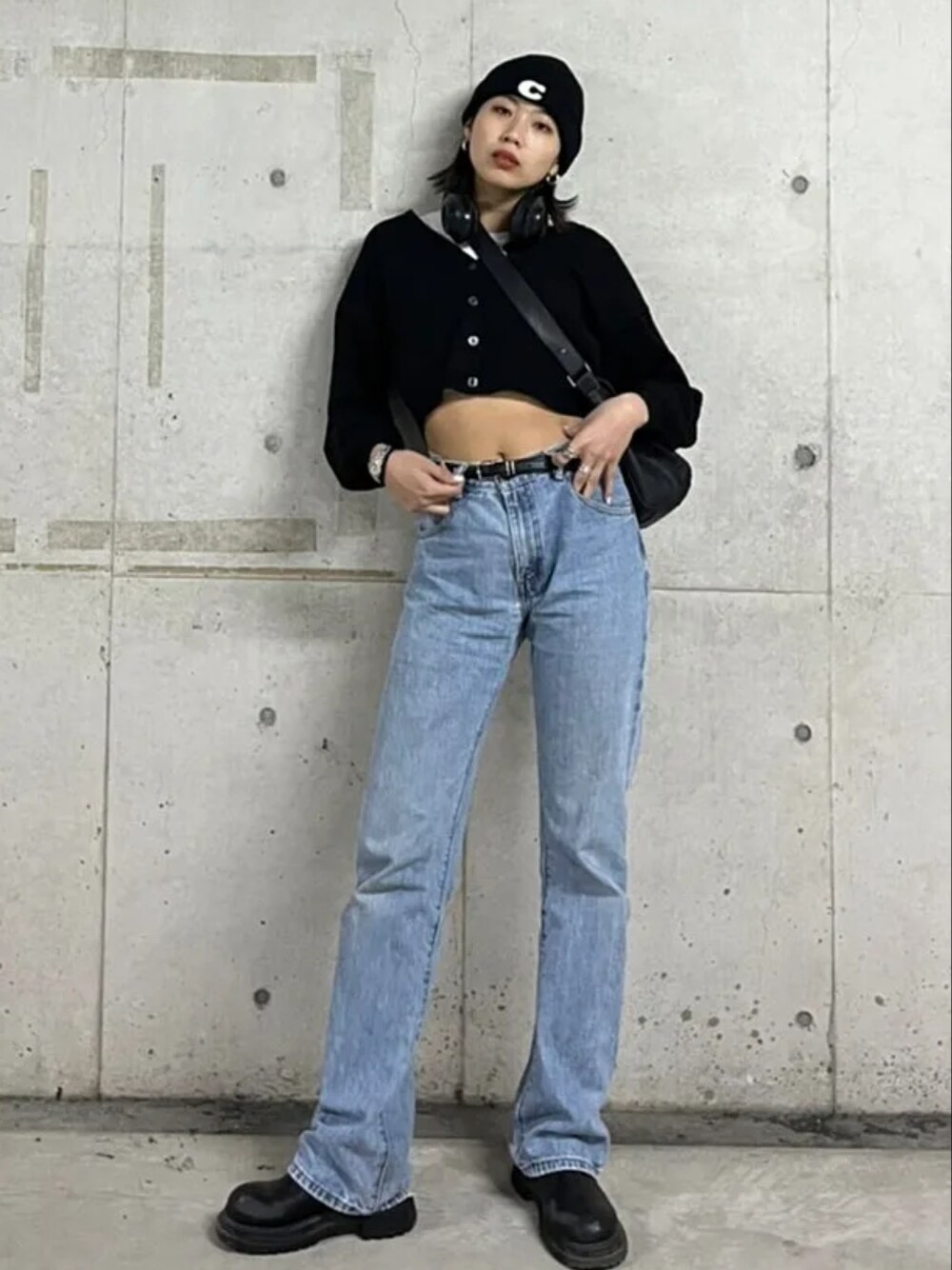 ブルー系のデニムパンツ、ブラック系のカーディガン/ボレロ、ブラック系のブーツを着用したレディースの冬コーディネートの2枚目の写真