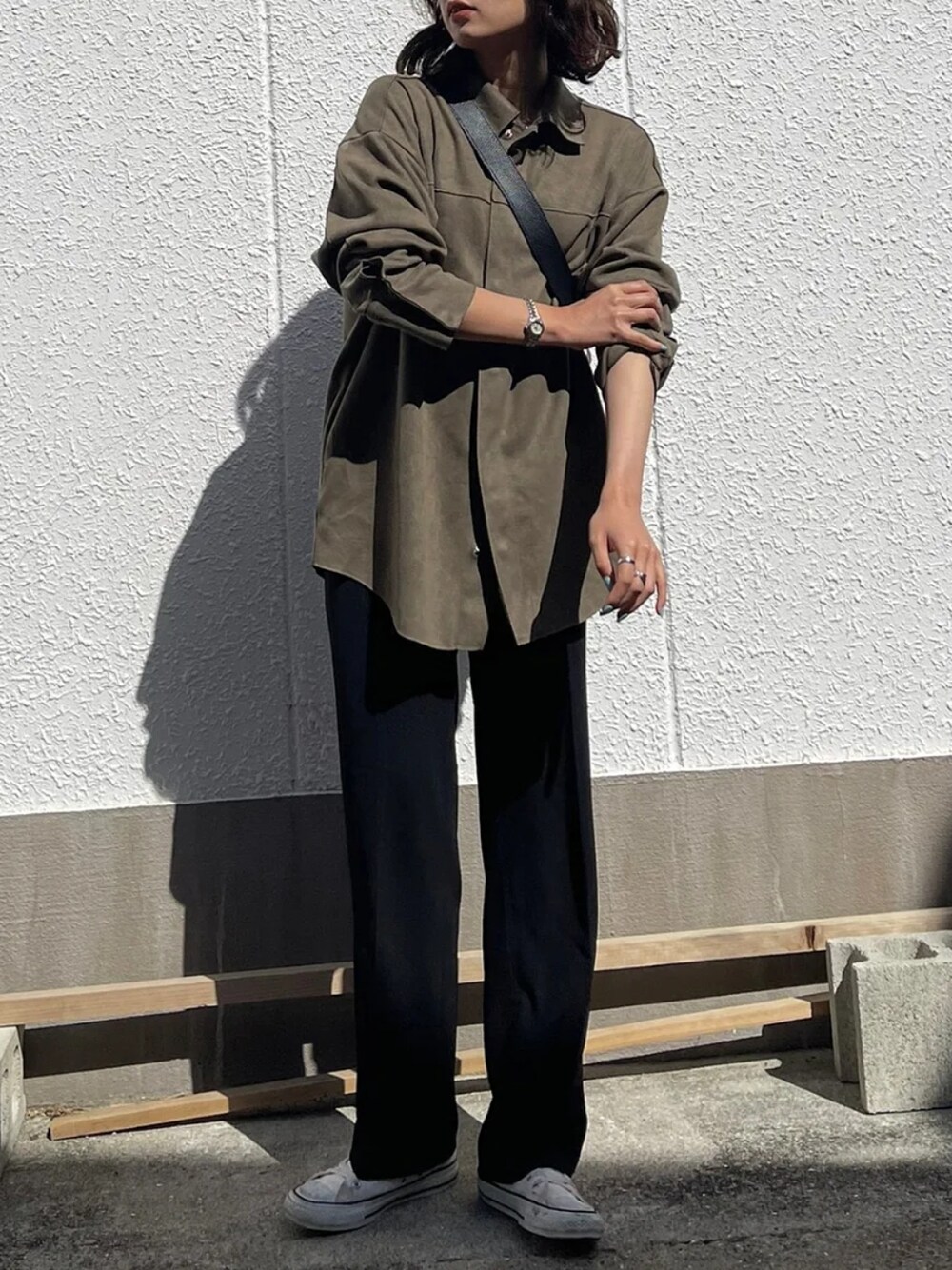 ブラウン系のシャツ/ブラウス、ブラック系のスラックス、ホワイト系のスニーカーを着用したレディースの春コーディネートの2枚目の写真