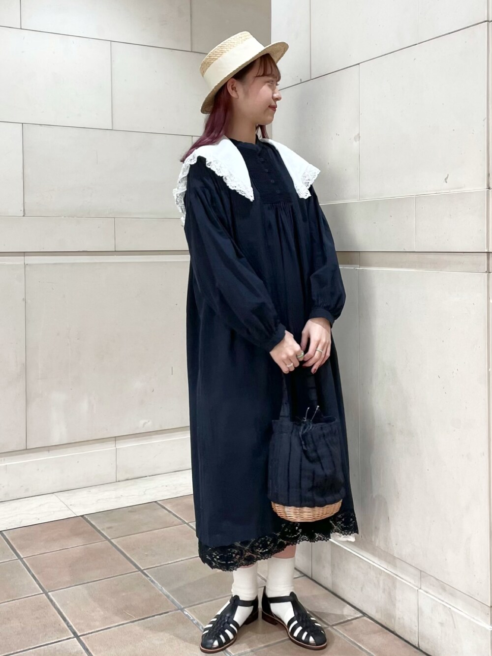 ブラック系のワンピース、ブラック系のかごバッグ、ブラック系のサンダルを着用したレディースの春コーディネートの1枚目の写真