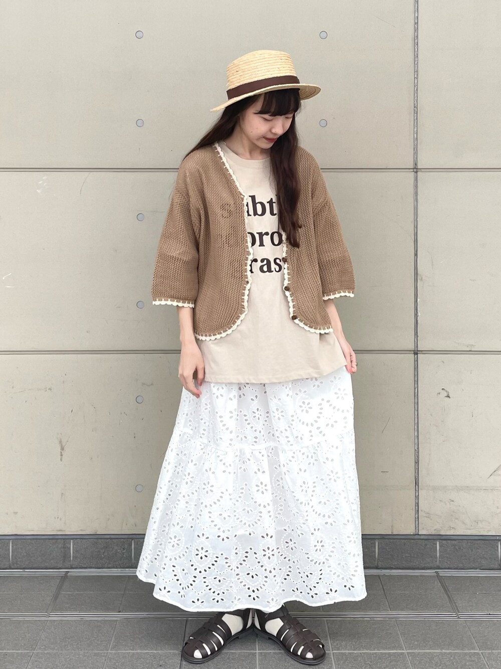 ベージュ系のTシャツ/カットソー、ブラウン系のカーディガン/ボレロ、ホワイト系のスカートを着用したレディースの春コーディネートの1枚目の写真