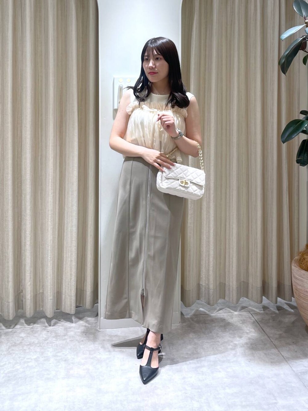 ベージュ系のスカート、ホワイト系のTシャツ/カットソー、ホワイト系のショルダーバッグを着用したレディースの春コーディネートの1枚目の写真