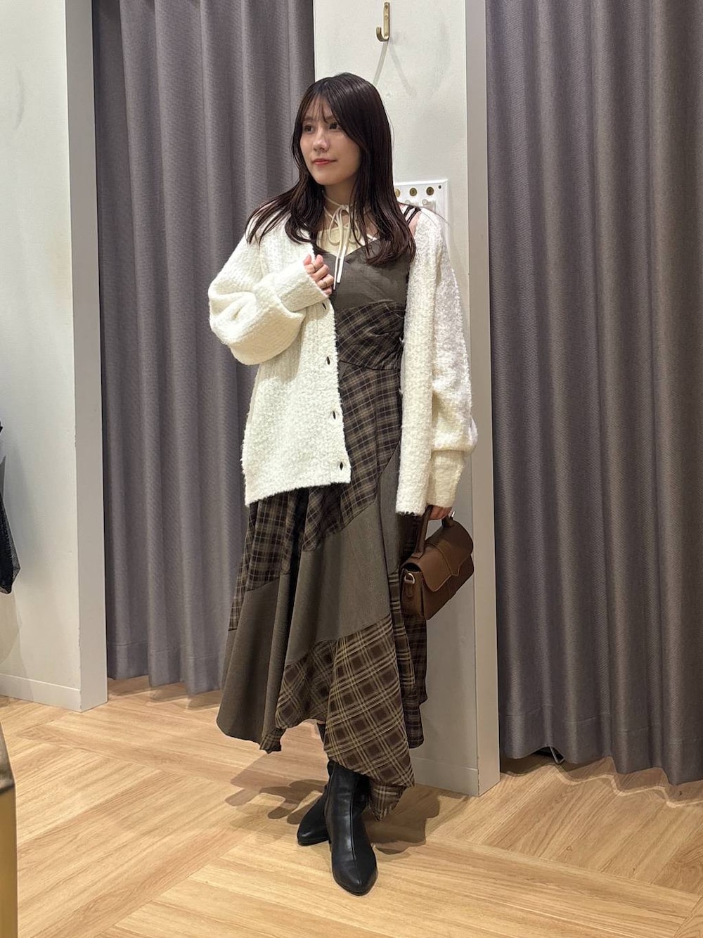 ホワイト系のカーディガン/ボレロ、ブラウン系のワンピース、ホワイト系のキャミソールを着用したレディースの秋コーディネートの1枚目の写真