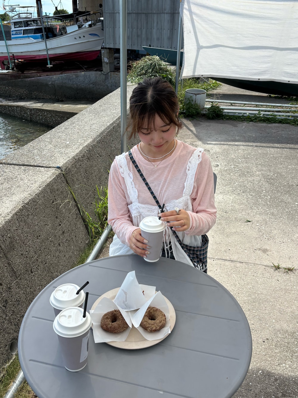 ホワイト系のベスト、ピンク系のTシャツ/カットソー、ブラウン系のバッグを着用したレディースの秋コーディネートの1枚目の写真