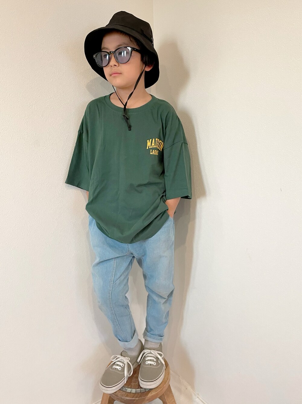 ベージュ系のスニーカー、ブルー系のデニムパンツ、グリーン系のTシャツ/カットソーを着用したキッズの春コーディネートの1枚目の写真