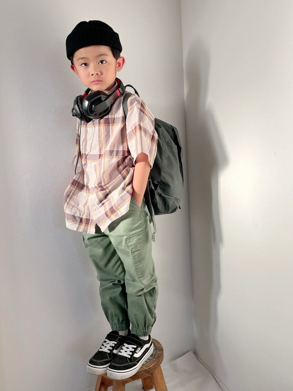 ブラック系のスニーカー、グリーン系のパンツ、グリーン系のバックパック/リュックを着用したキッズの春コーディネートの1枚目の写真