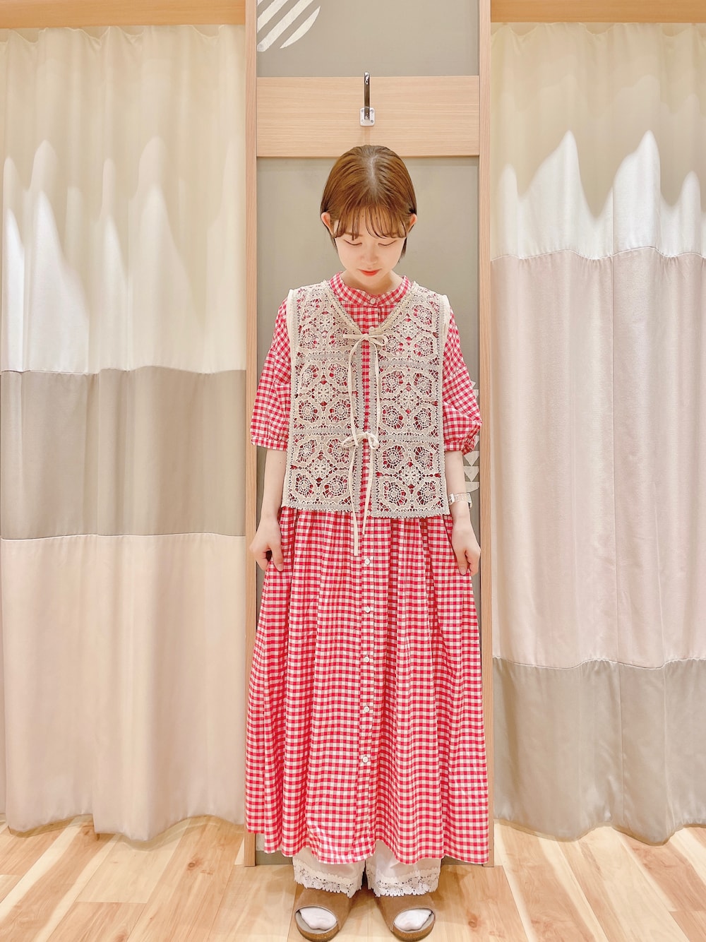 レッド系のワンピース、ホワイト系のベスト、ホワイト系のその他パンツを着用したレディースの夏コーディネートの1枚目の写真