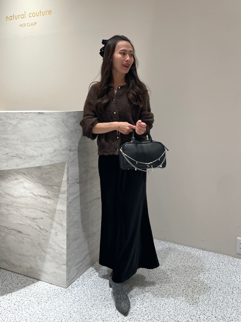 ブラック系のスカート、ブラウン系のカーディガン/ボレロを着用したレディースの秋コーディネートの1枚目の写真