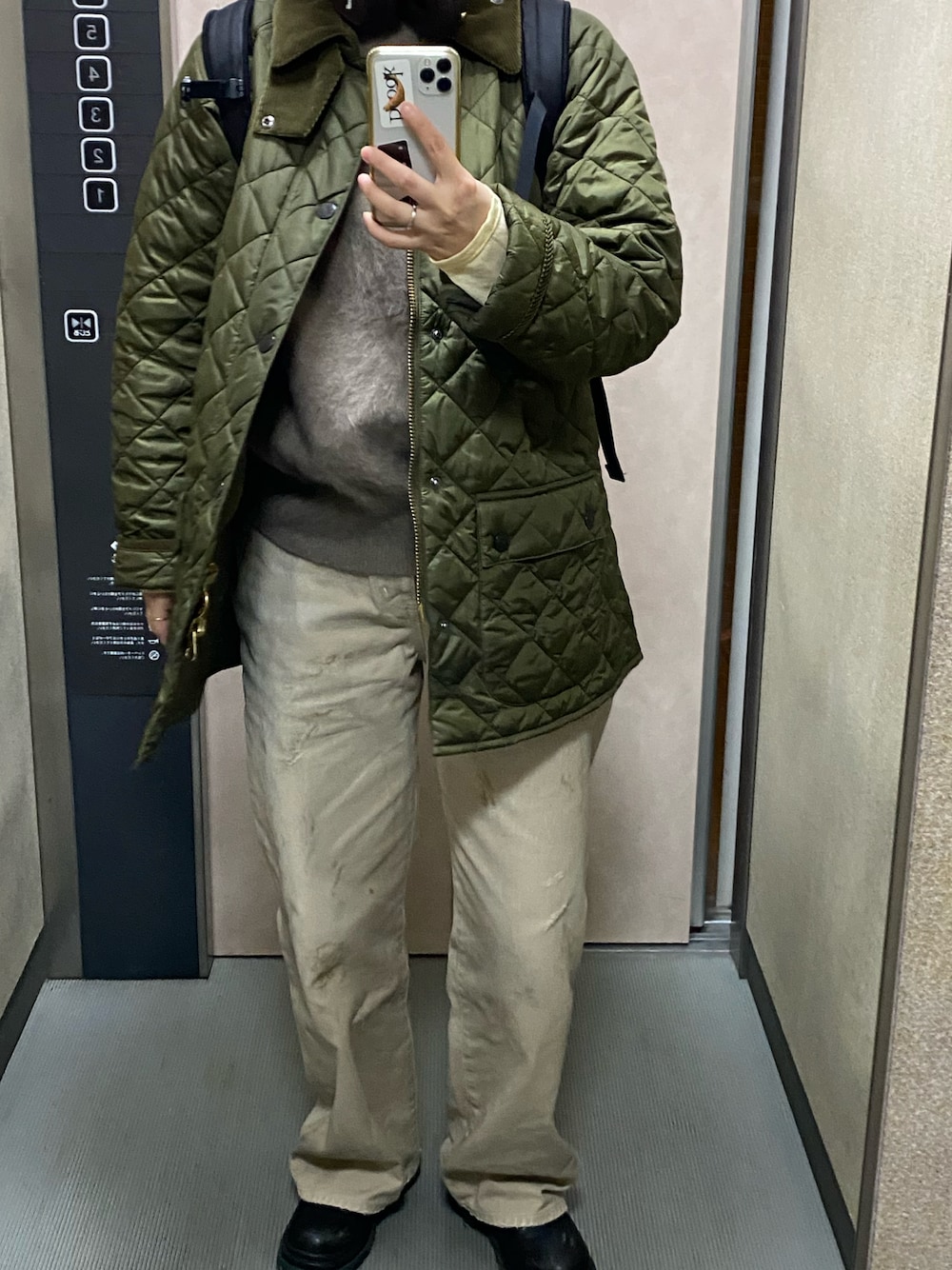 グリーン系のブルゾン、ホワイト系のTシャツ/カットソー、ベージュ系のベストを着用したレディースの秋コーディネートの1枚目の写真