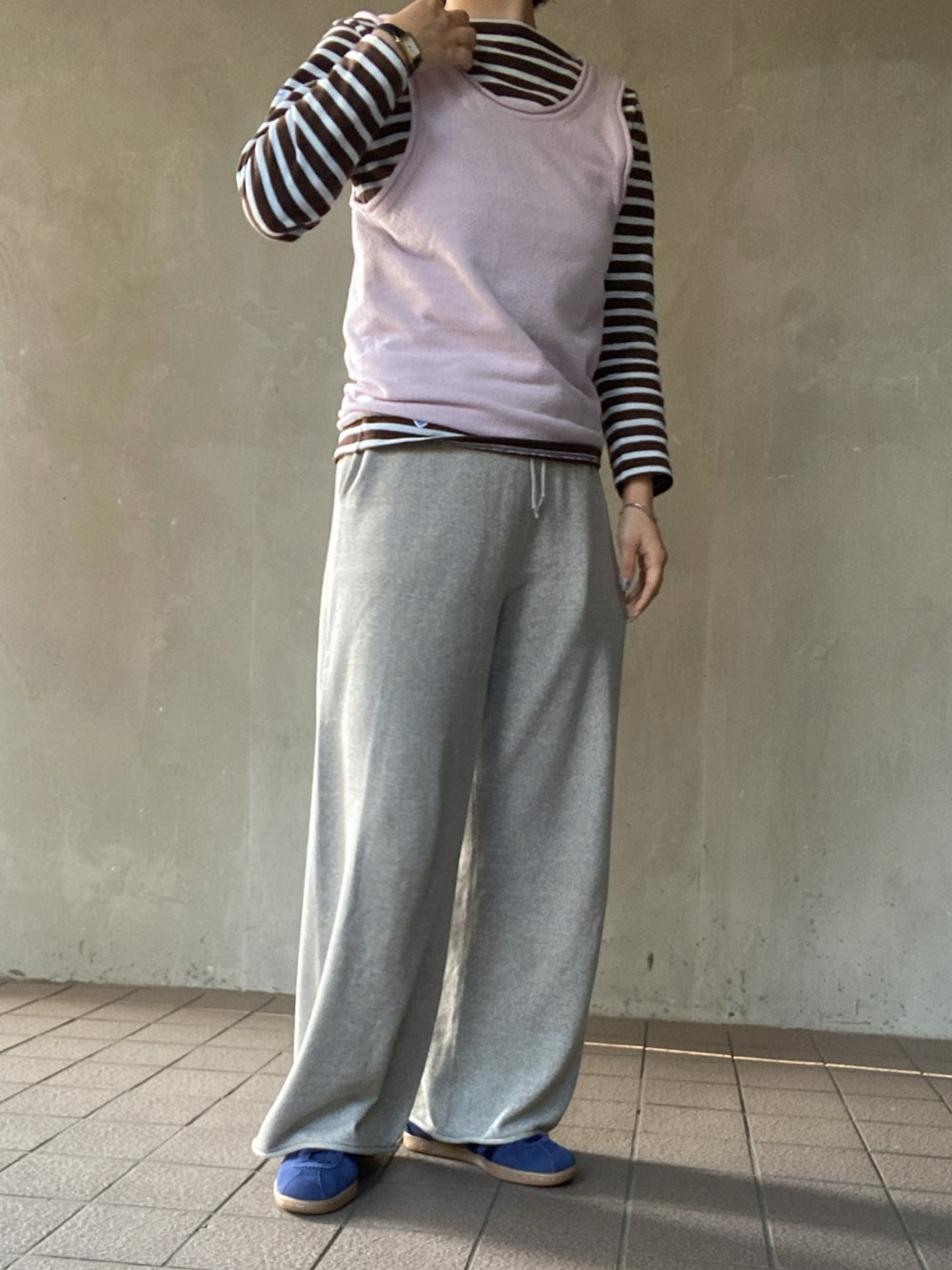 ピンク系のニット/セーター、ブラウン系のTシャツ/カットソー、グレー系のその他パンツを着用したレディースの秋コーディネートの1枚目の写真