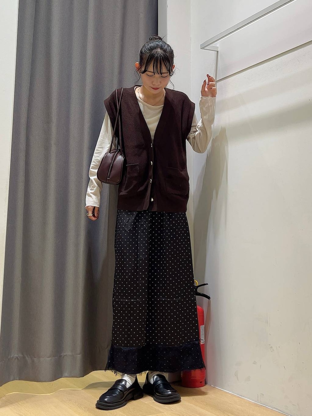 レッド系のボストンバッグ、ベージュ系のTシャツ/カットソー、その他のスカートを着用したレディースの秋コーディネートの1枚目の写真