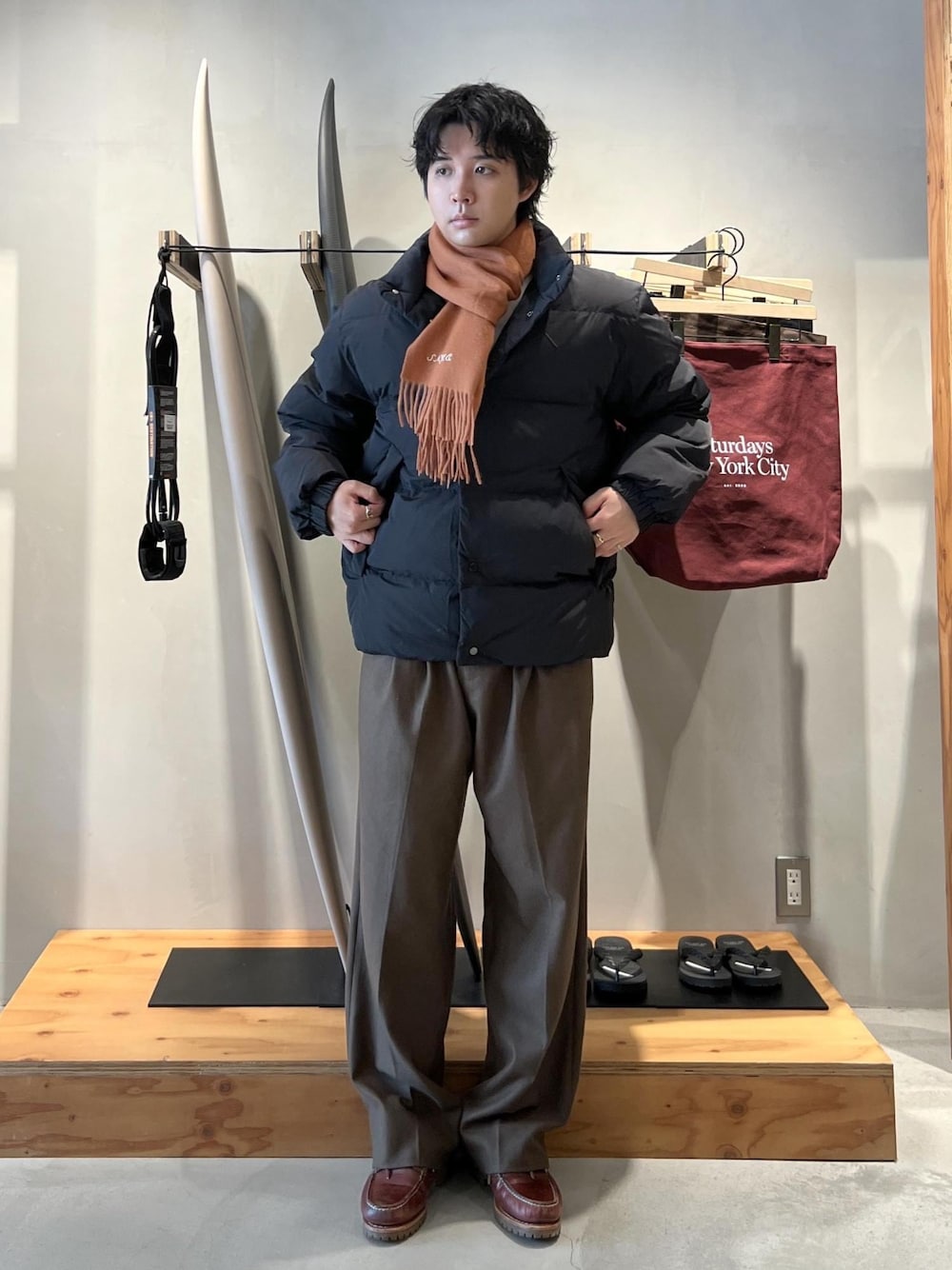 グリーン系のその他パンツ、ブラック系のブルゾン、オレンジ系のマフラーを着用したメンズの冬コーディネートの1枚目の写真