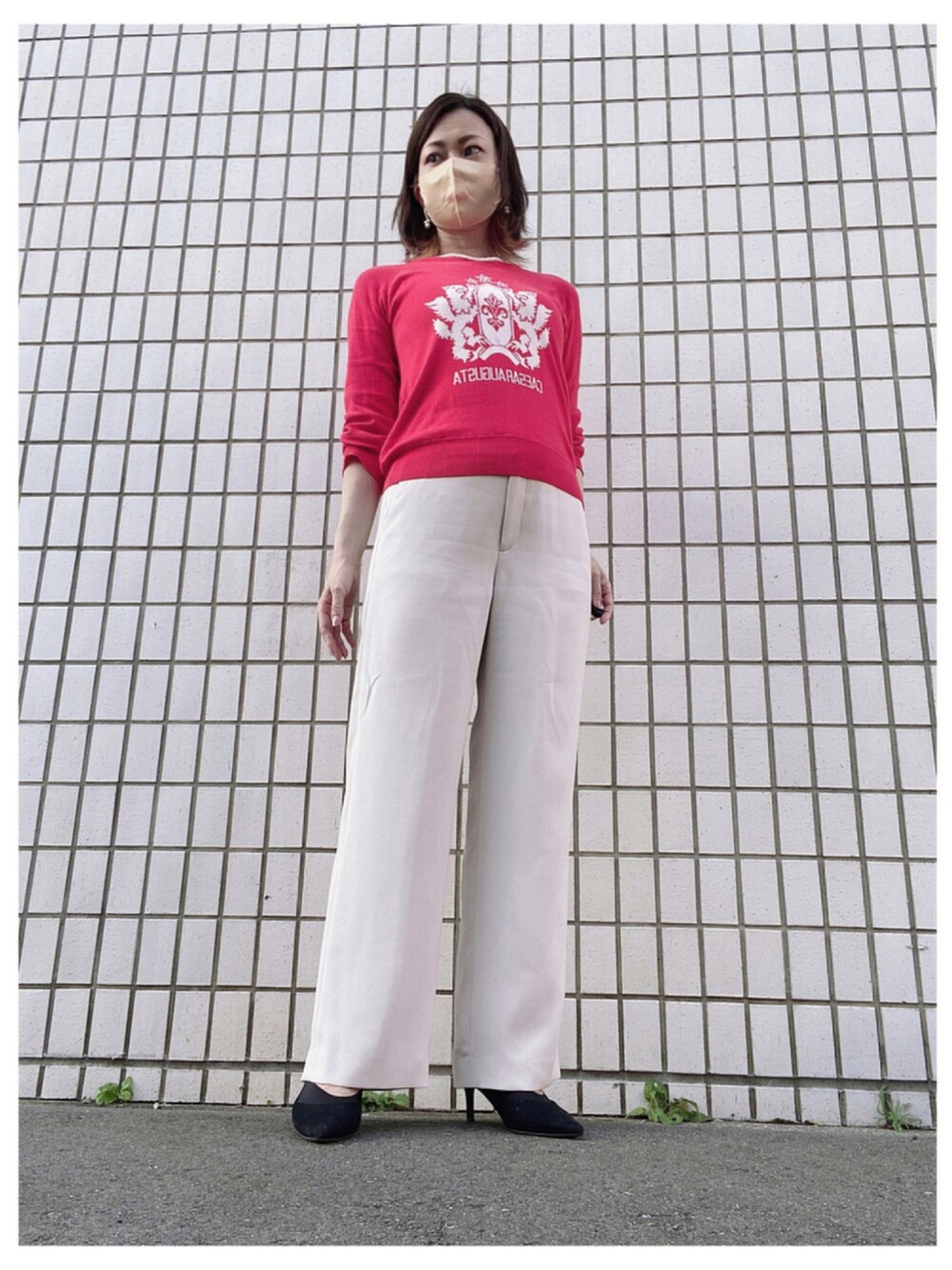 レッド系のニット/セーター、ホワイト系のパンツ、ブラック系のパンプスを着用したレディースの秋コーディネートの1枚目の写真