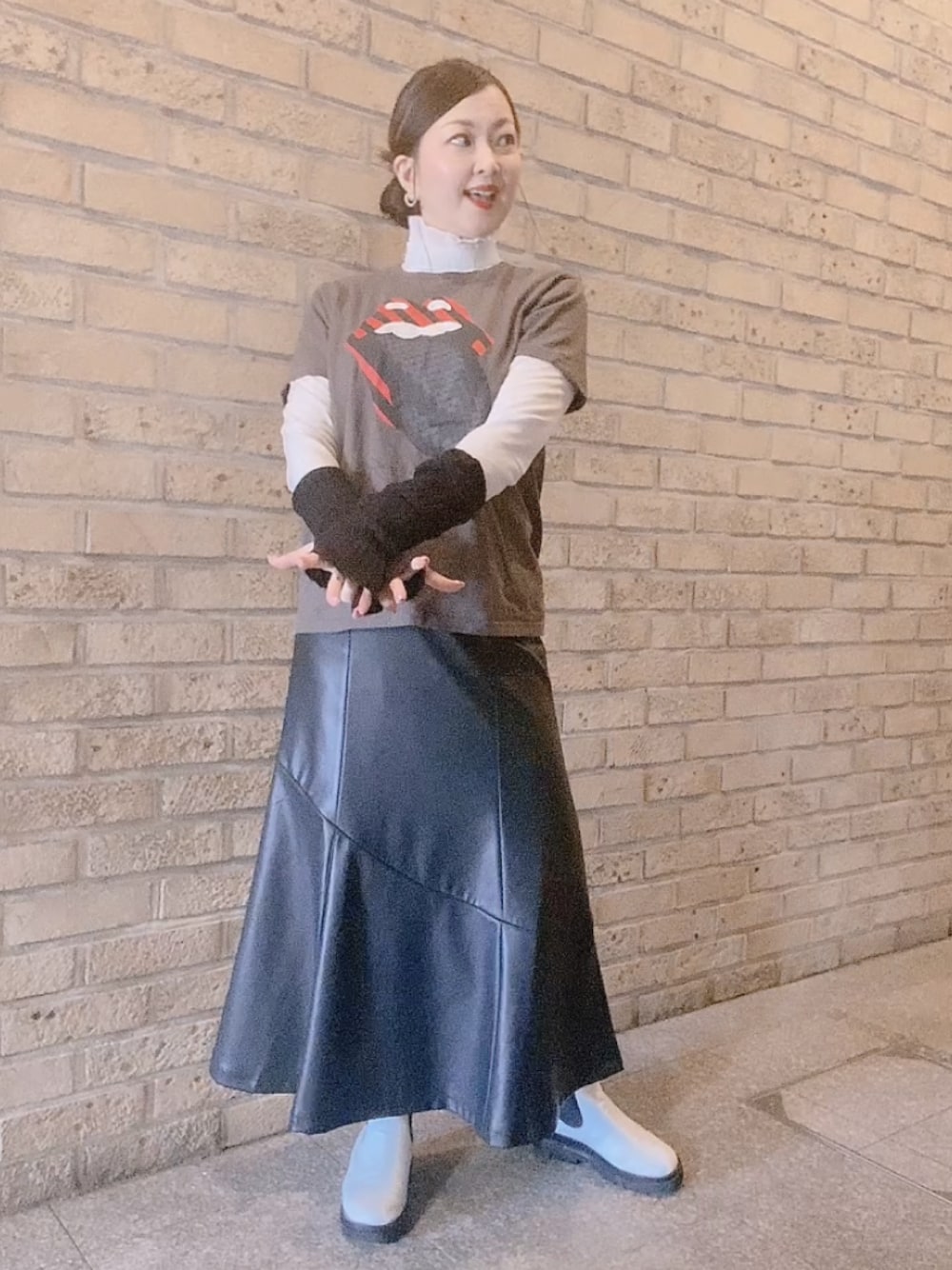 グレー系のTシャツ/カットソー、ブラック系のスカート、ホワイト系のレインシューズを着用したレディースの冬コーディネートの1枚目の写真