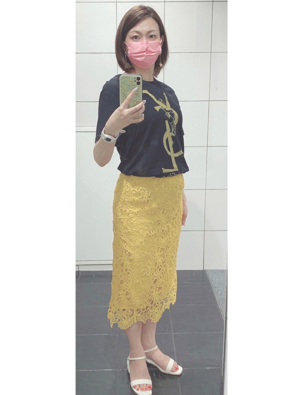 ブラック系のTシャツ/カットソー、イエロー系のスカート、ホワイト系のサンダルを着用したレディースの夏コーディネートの1枚目の写真