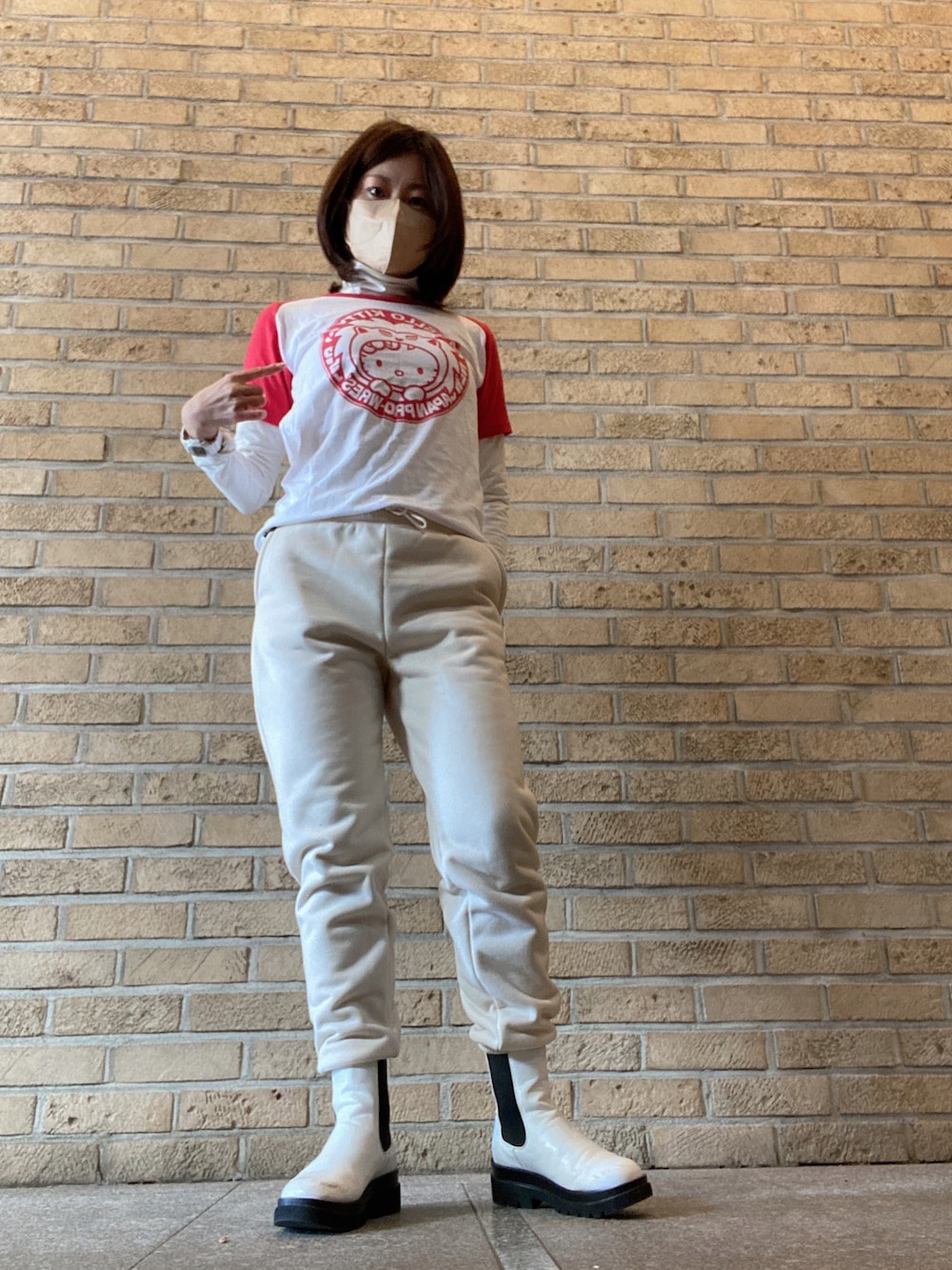 レッド系のTシャツ/カットソー、ホワイト系のスウェットパンツ、ホワイト系のレインシューズを着用したレディースの冬コーディネートの1枚目の写真