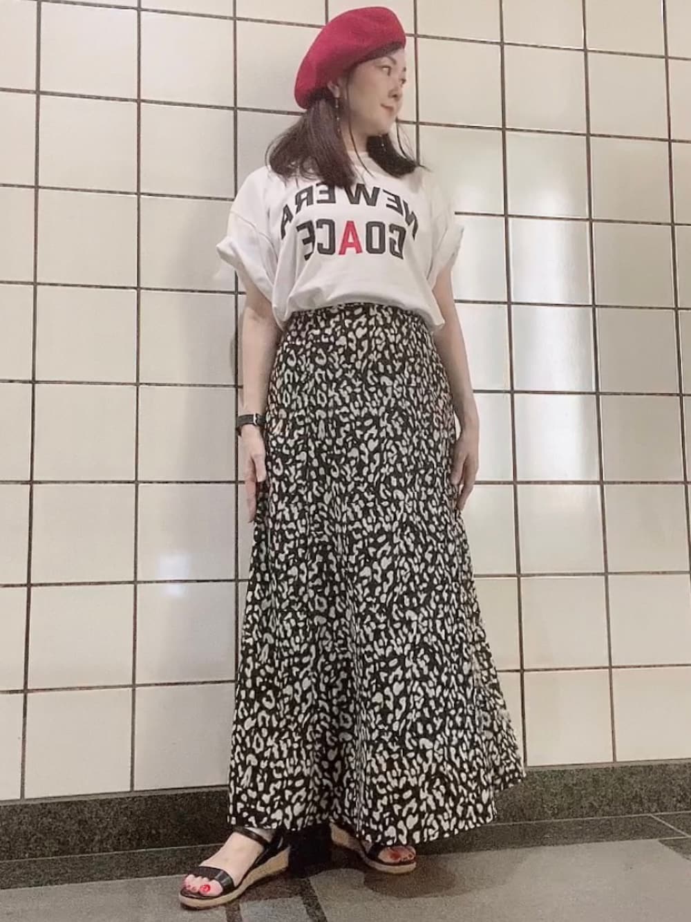 ホワイト系のTシャツ/カットソー、ブラック系のスカート、ブラック系のサンダルを着用したレディースの秋コーディネートの1枚目の写真