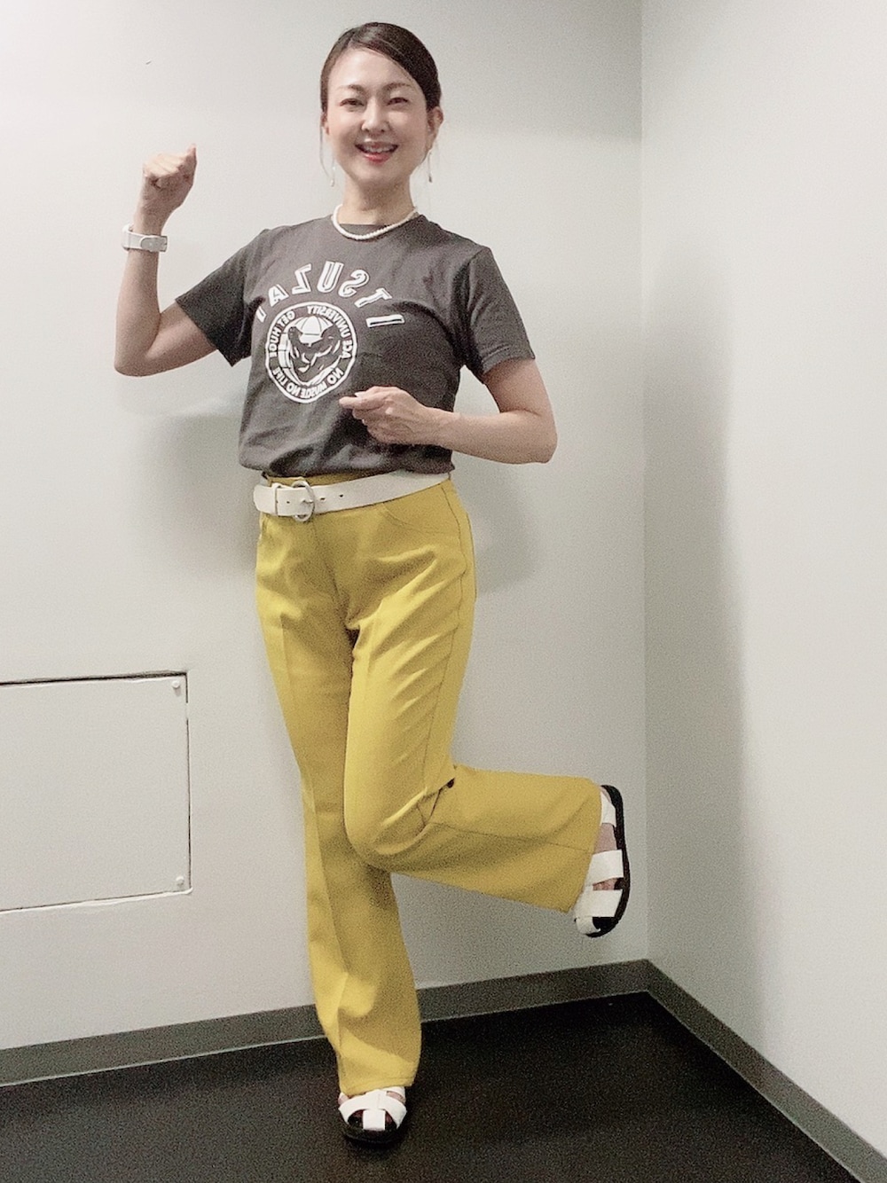 イエロー系のスラックス、ホワイト系のサンダル、グレー系のTシャツ/カットソーを着用したレディースの夏コーディネートの1枚目の写真