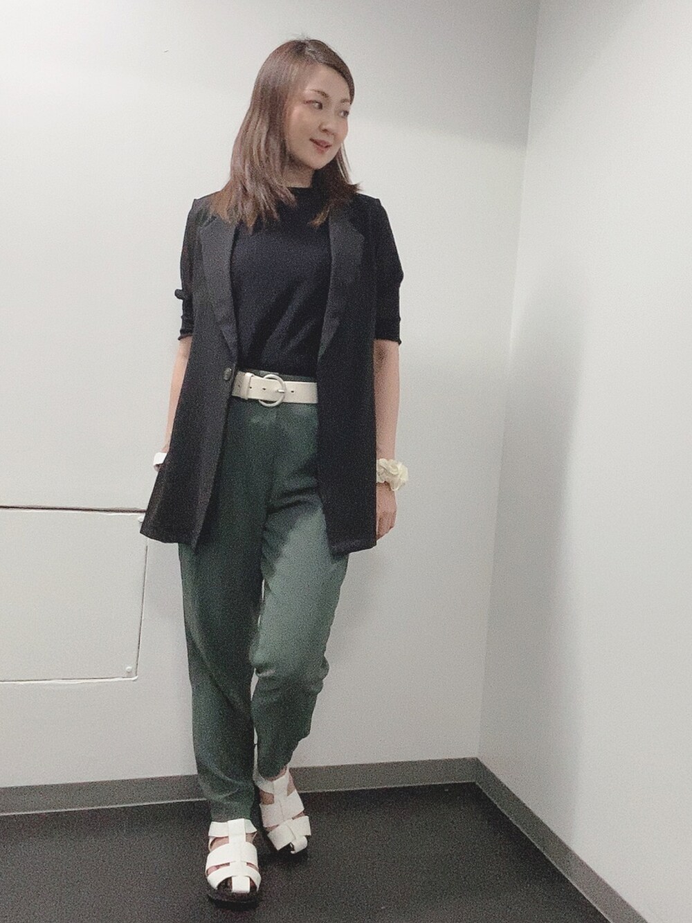 ブラック系のニット/セーター、グリーン系のその他パンツ、ホワイト系のサンダルを着用したレディースの夏コーディネートの1枚目の写真