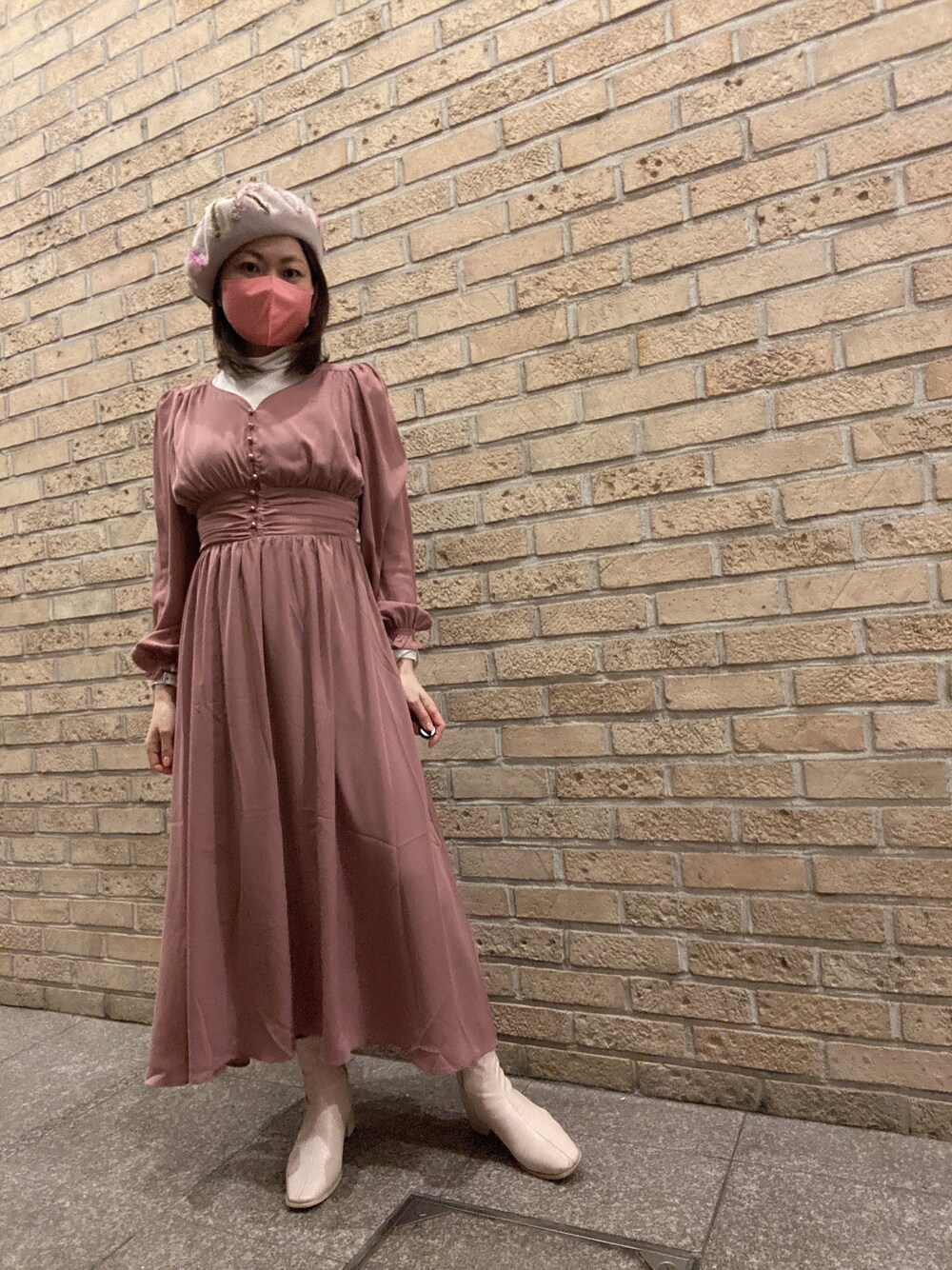 ピンク系のワンピース、ホワイト系のTシャツ/カットソー、ホワイト系のブーツを着用したレディースの冬コーディネートの1枚目の写真