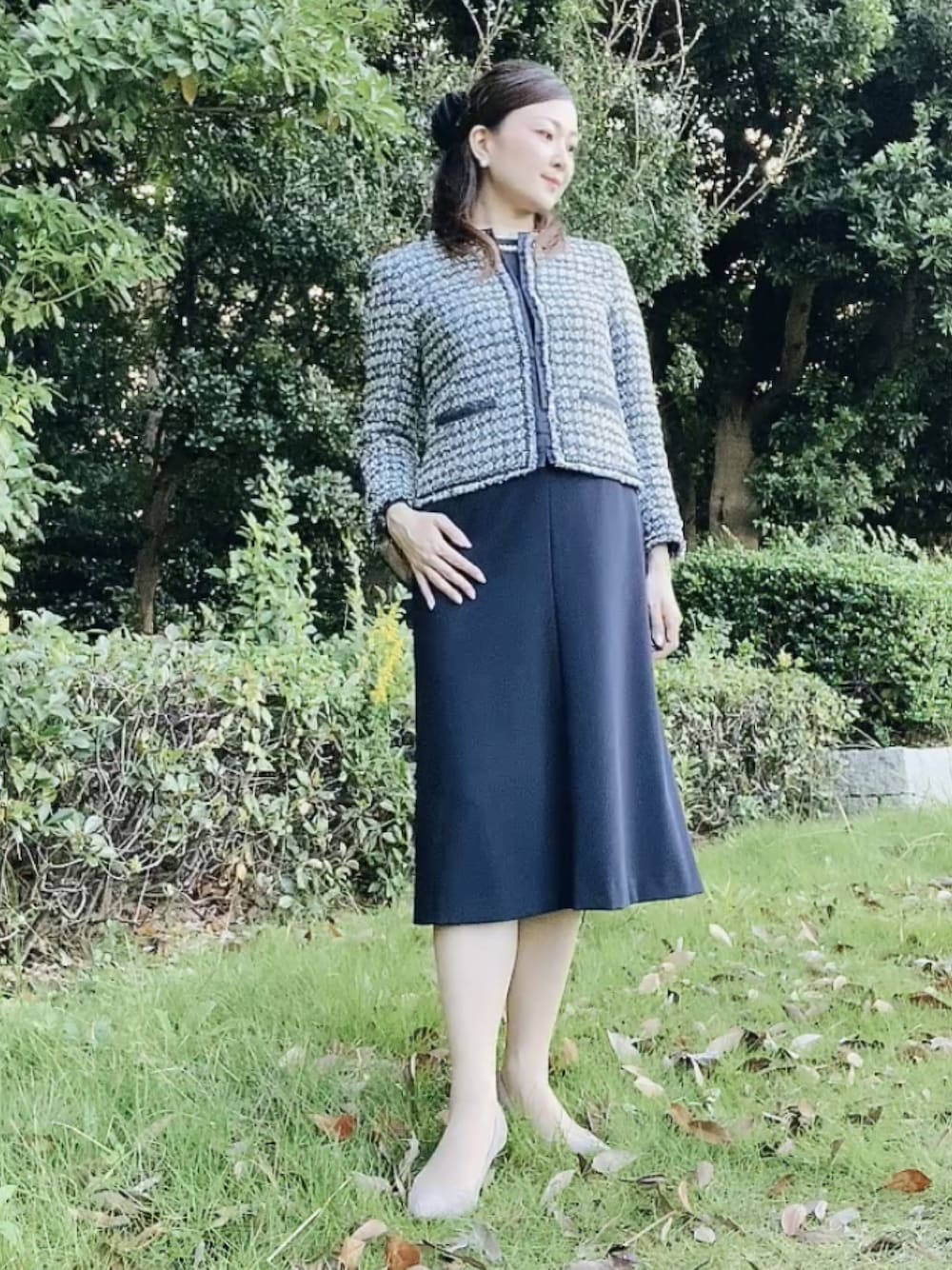 ブルー系のスーツセット、ベージュ系のパンプス、ホワイト系のネックレスを着用したレディースの秋コーディネートの1枚目の写真