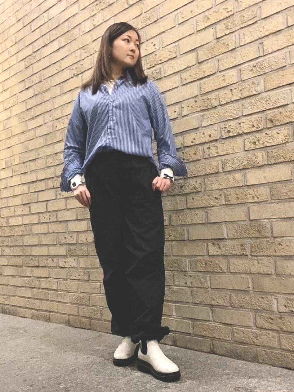 ブルー系のシャツ/ブラウス、ブラック系のカーゴパンツ、ホワイト系のレインシューズを着用したレディースの春コーディネートの1枚目の写真